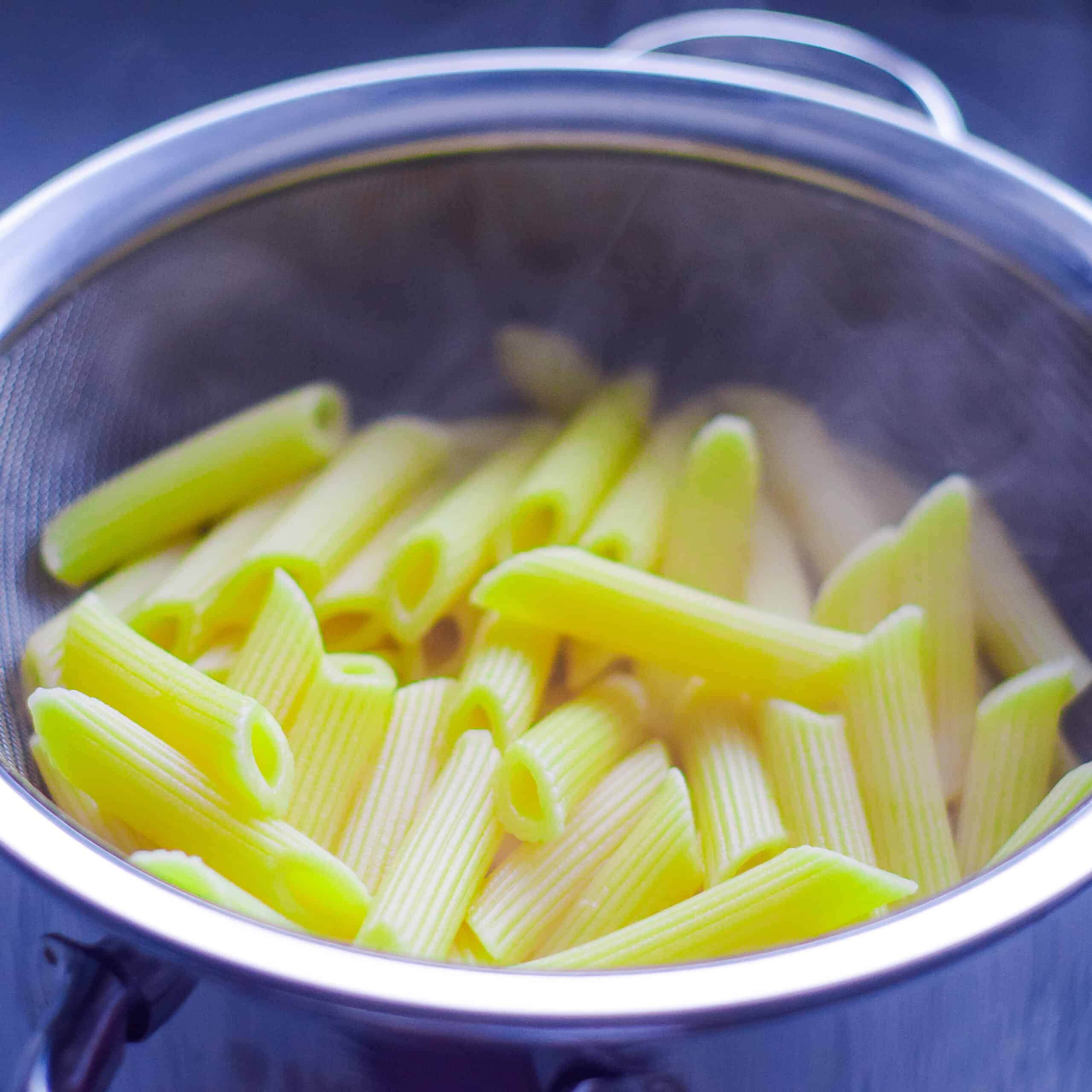 Pasta draining in a sieve.