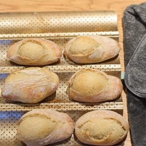crusty white bread rolls on a tray
