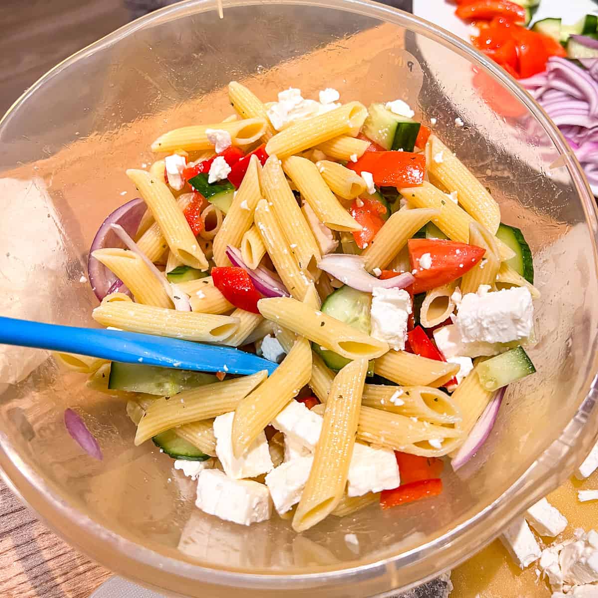 greek pasta salad with feta in a mixing bowl