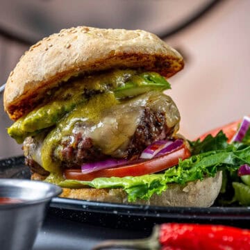 Beef burger with cheese on a plate with salad.