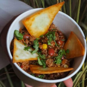 A bowl of chilli con carne topped with coriander.