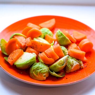 Carrots and sprouts with pepper on a plate.