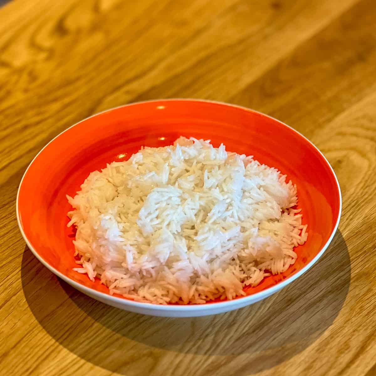 An orange bowl full of steamed rice.