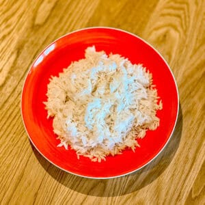 An orange bowl containing steamed rice.