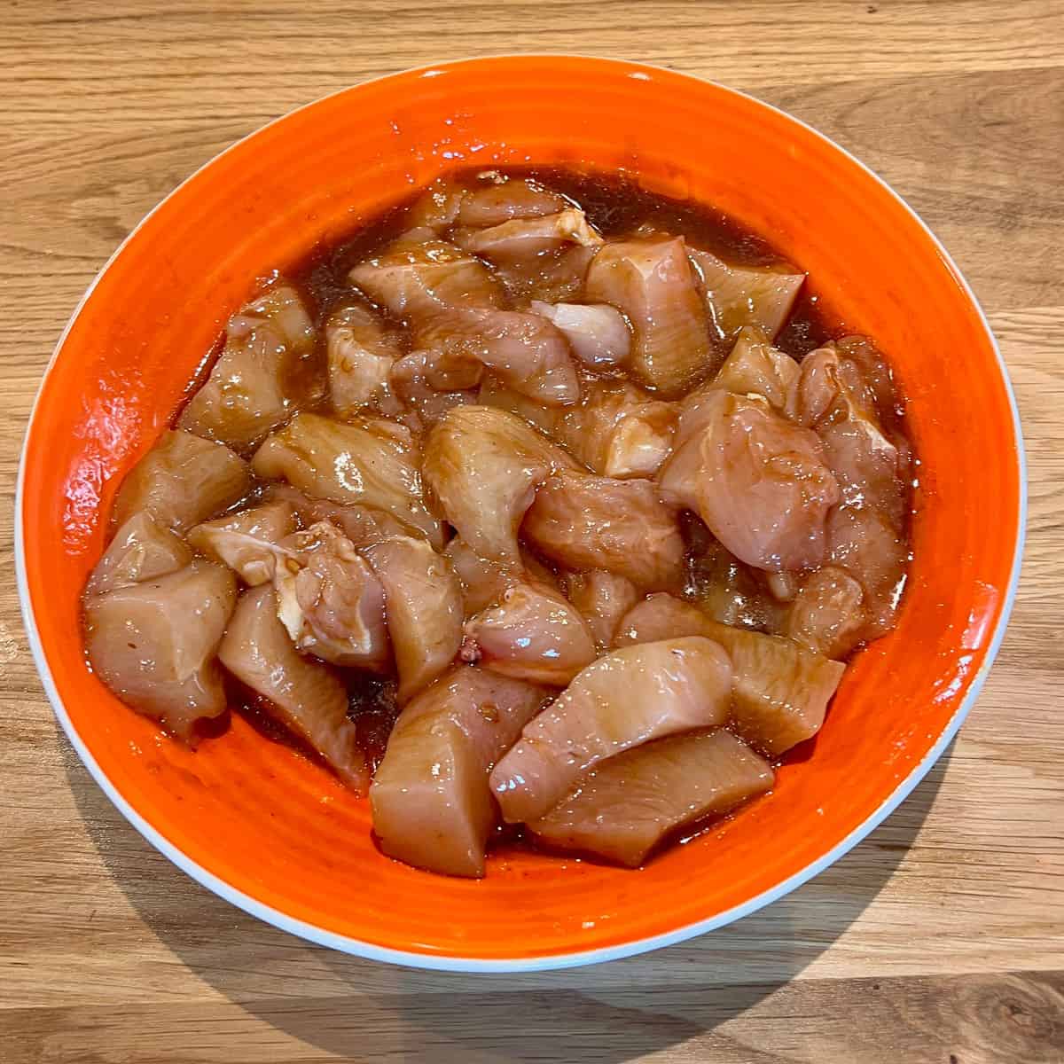 Raw chicken in a soy and peri peri, sesame and soy marinade.