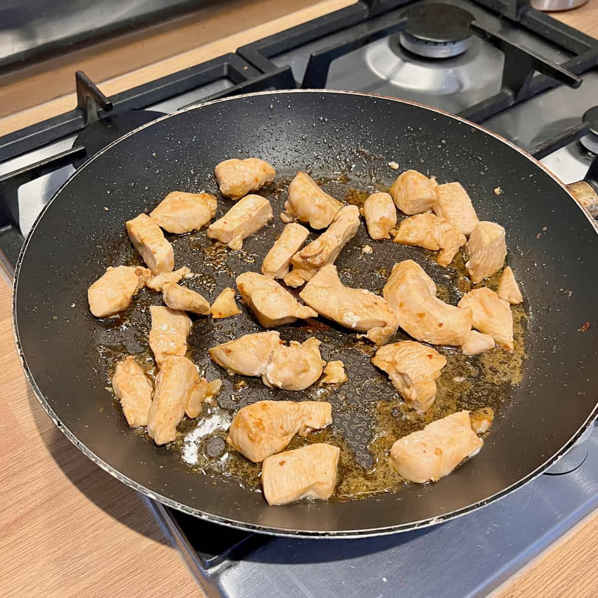 Marinate chicken cooking in a frying pan.