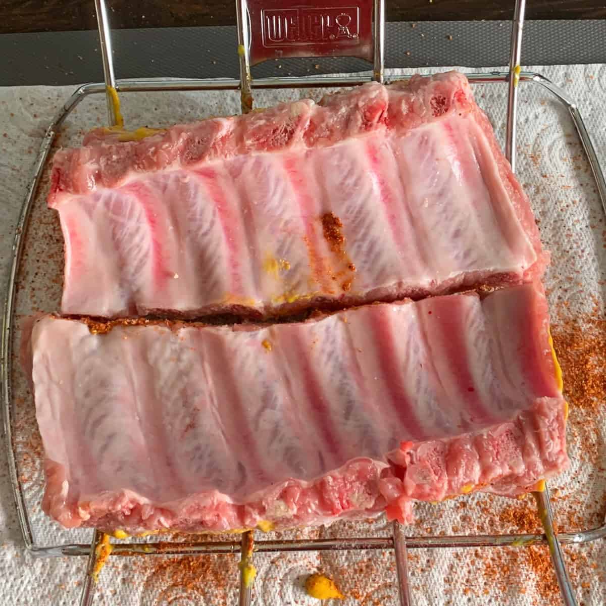 Raw rack of ribs with some rub coating.