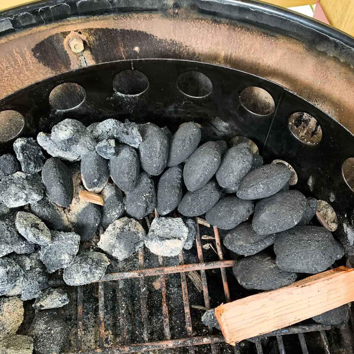 Charcoal briquettes configured in a snake method.
