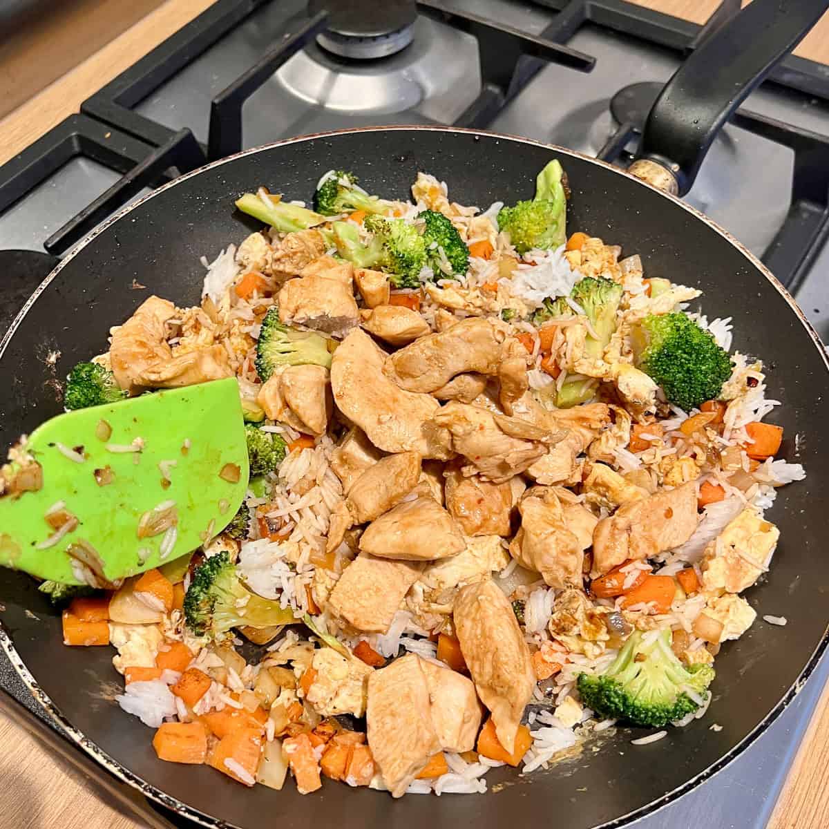 Stir fry chicken in a frying pan with vegetables.