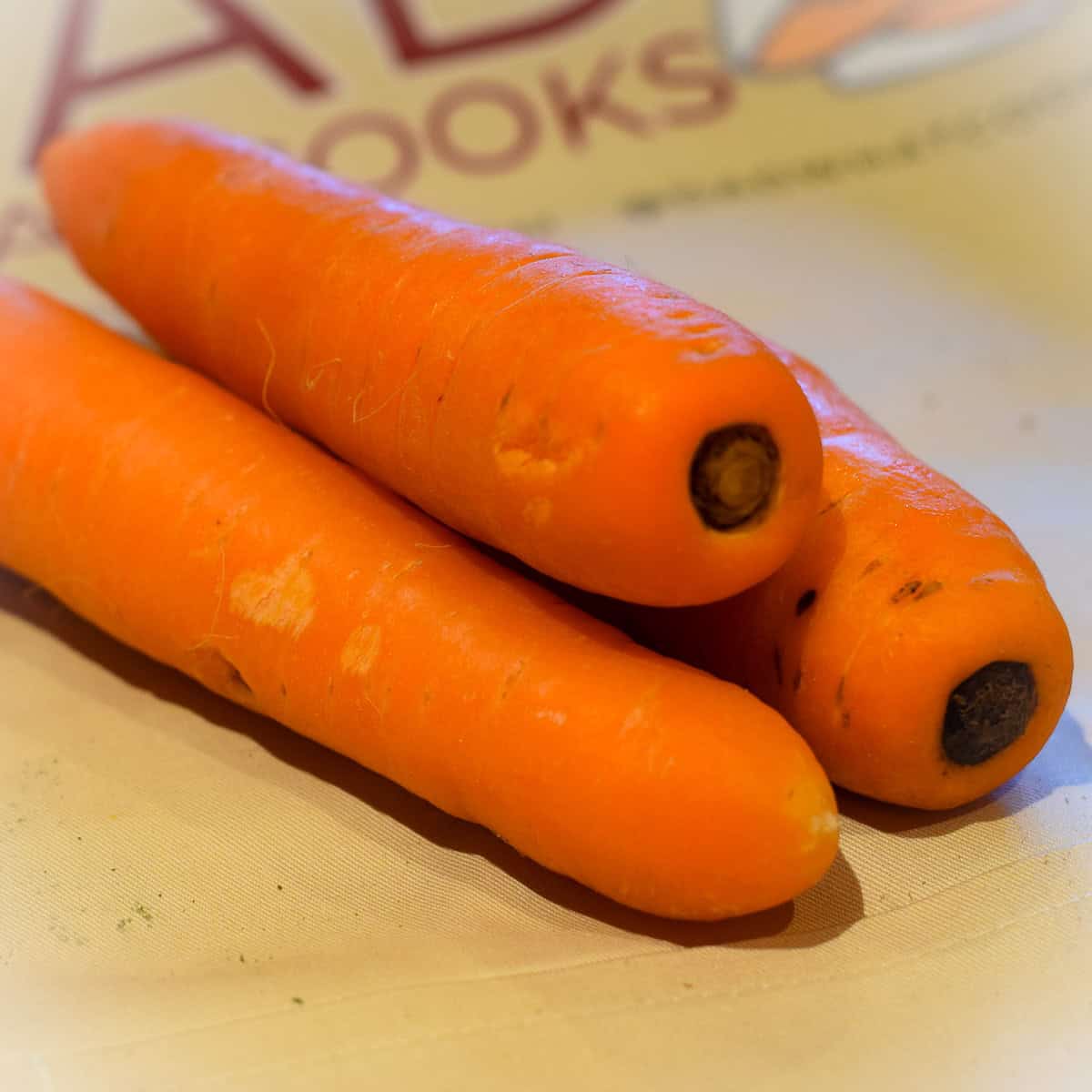 Three raw carrots on a table.