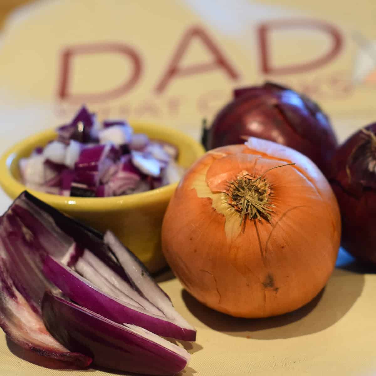 A variety of white and red onions chopped in various forms.