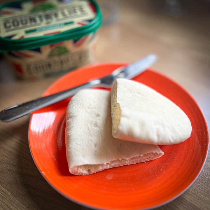 Pitta cut in half on a plate with butter.