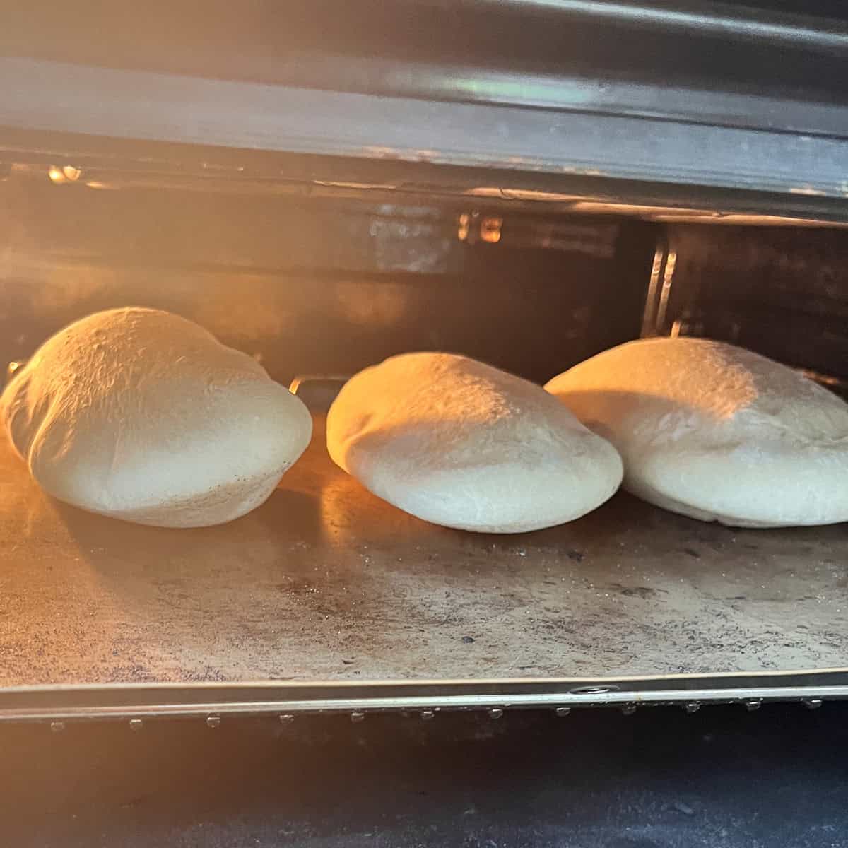 Pitta bread rising in the oven.