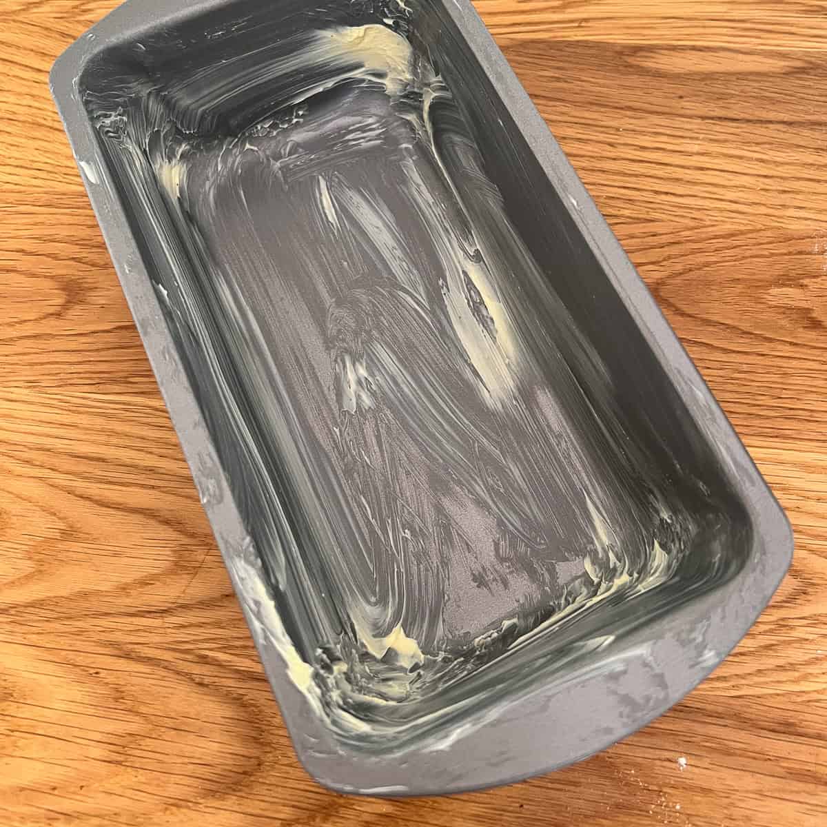 A bread tin greased with butter.