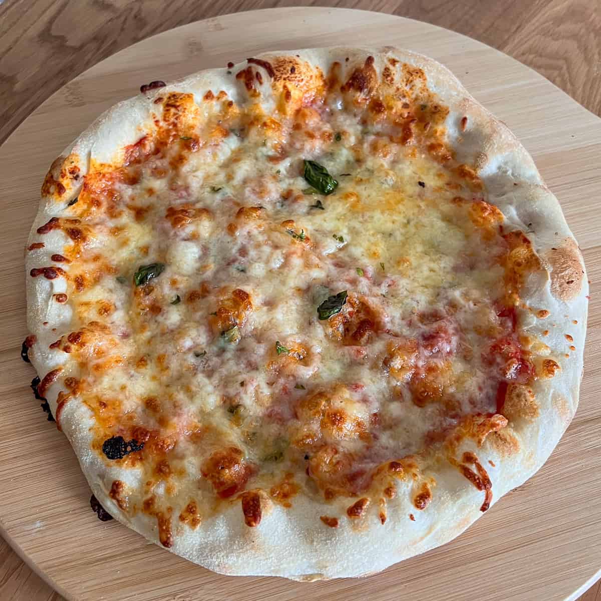 Margherita pizza on chopping board.