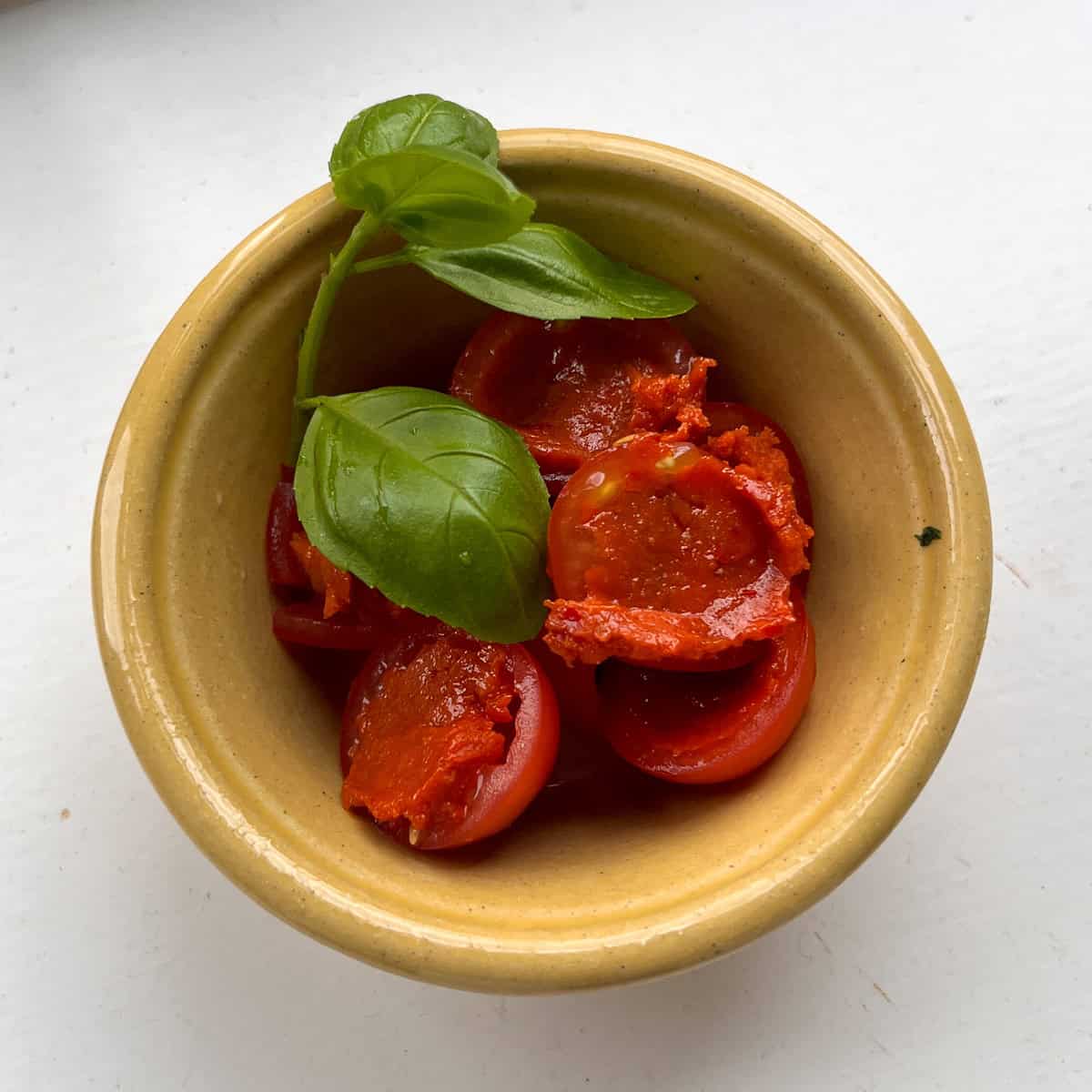 Close up of Nduja stuffed tomatoes with basil.