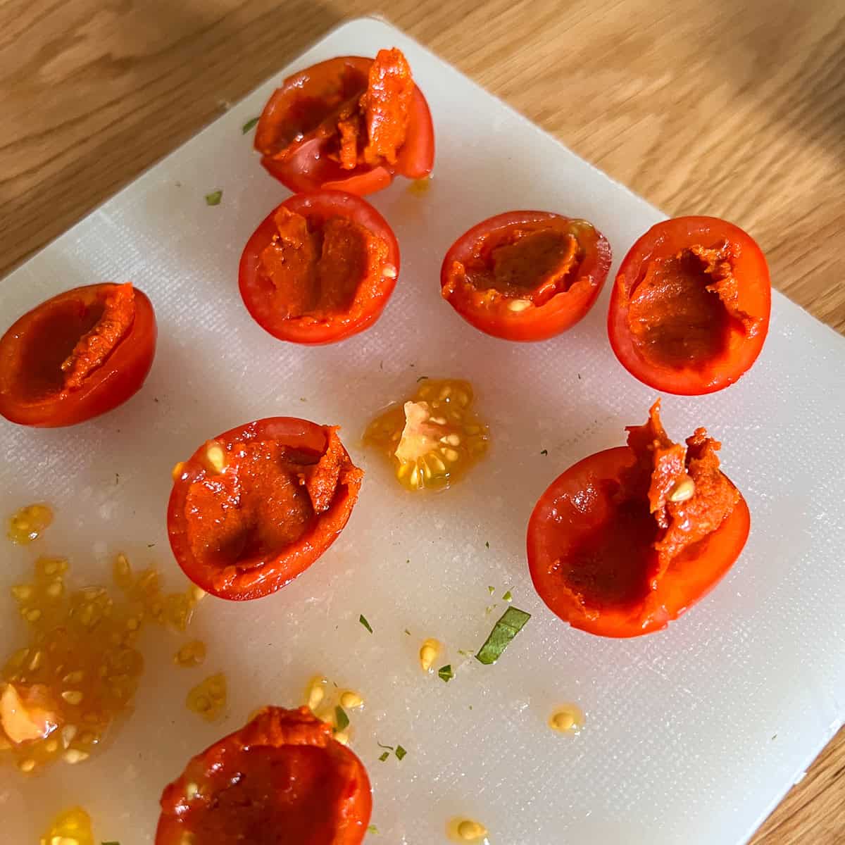 Nduja stuffed tomatoes on a chopping board.