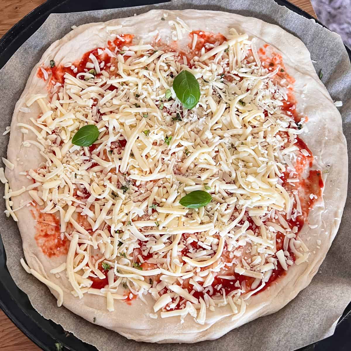 Uncooked cheese and tomato margherita pizza.
