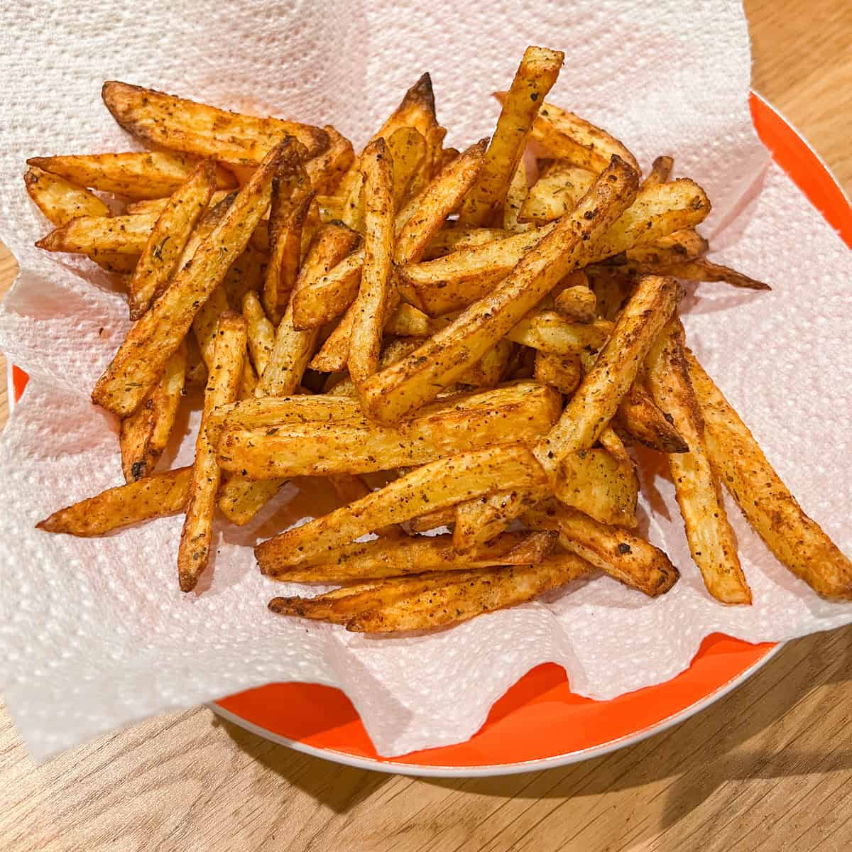 Air Fryer Cajun fries in a bowl seasoned.