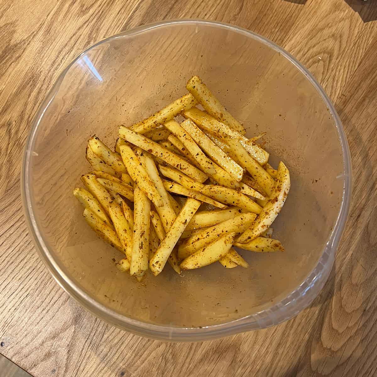 Raw chipped potato seasoned and oiled.