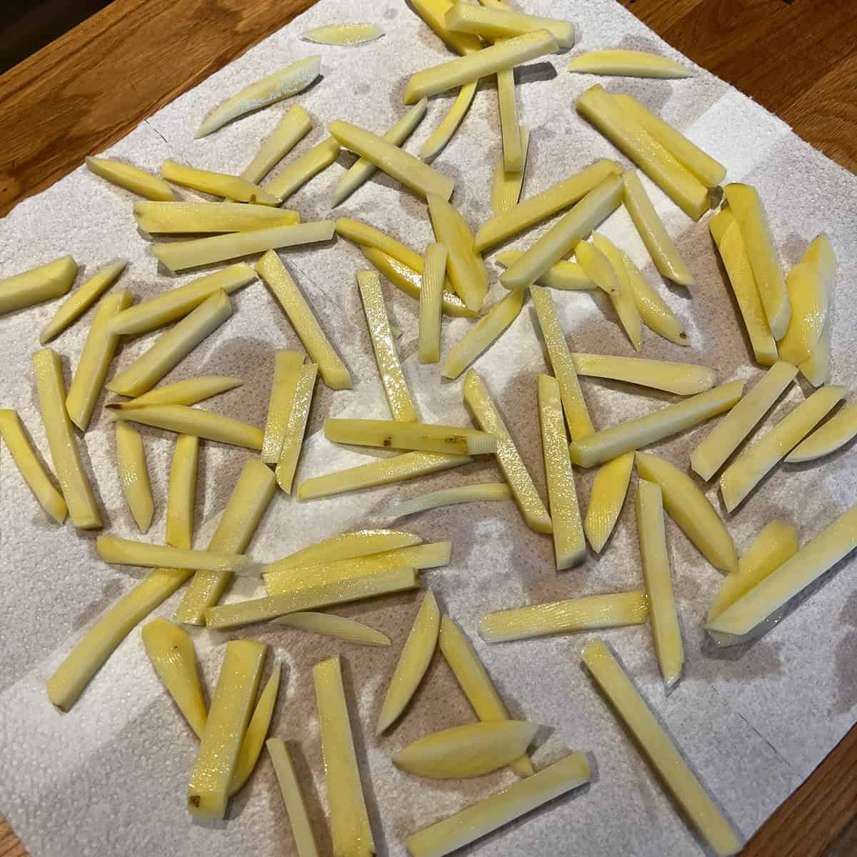 Drying out cut fries on kitchen roll.