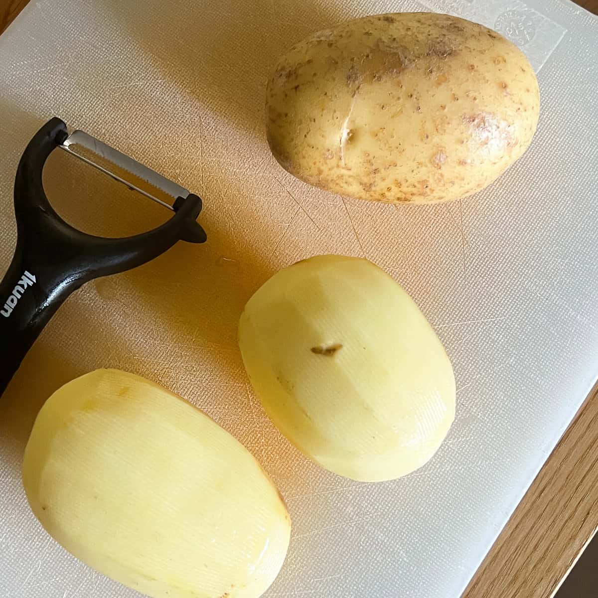 Raw potatoes peeled and unpeeled.