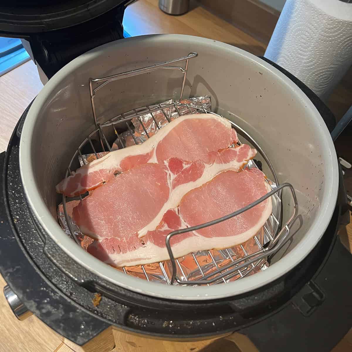 Bacon mid cooking in a ninja Foodi air fryer.