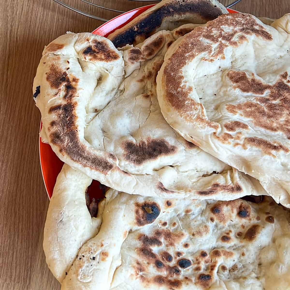 Cooked naan breads on a plate.