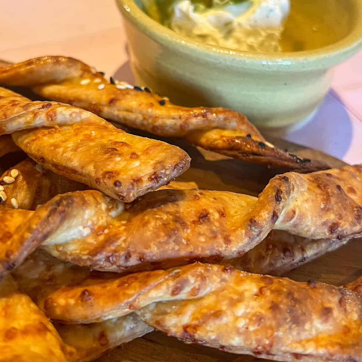 Crispy cheese straws on a serving platter.