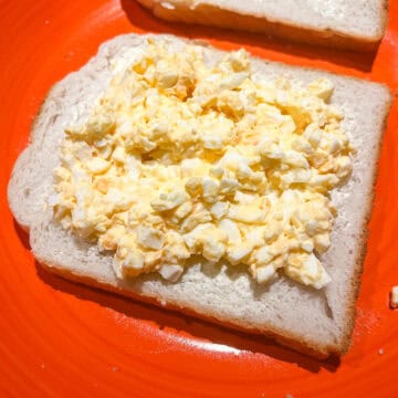 Egg mayo and mustard spread on a piece of bread.