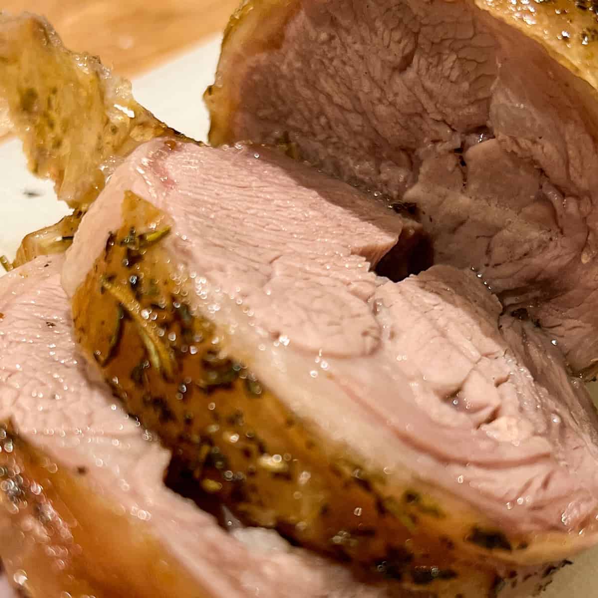Close up of roast lamb with mint and rosemary.