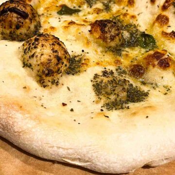 Garlic pizza bread on cutting board.