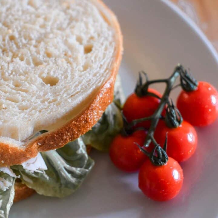 Chicken salad sandwich and tomatoes on the vine.