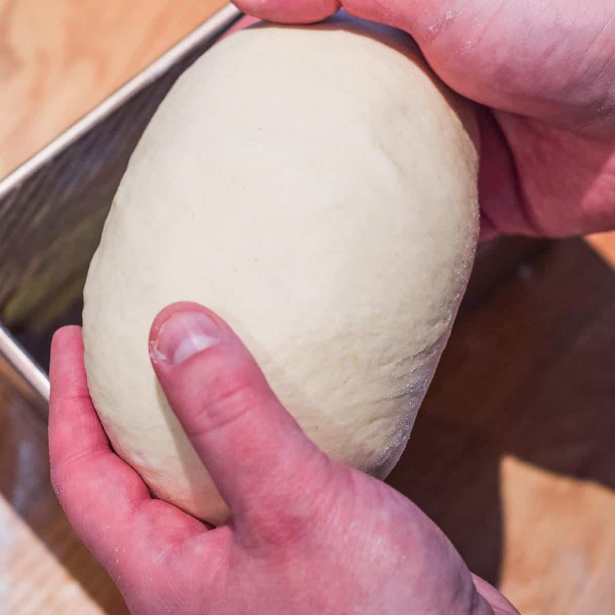 Placing dough into greased pullman loaf tin.