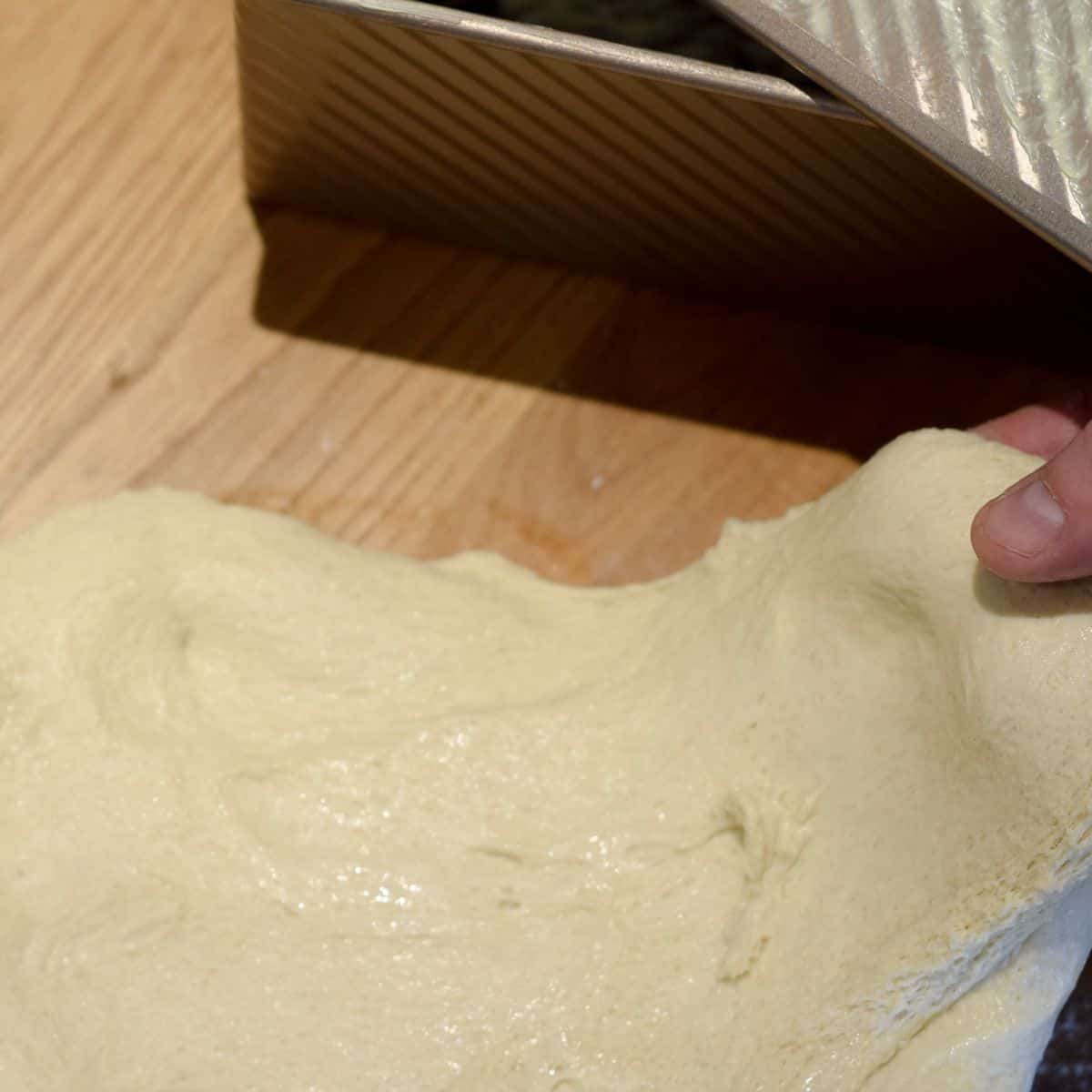 Stretching dough once risen ready for second prove.