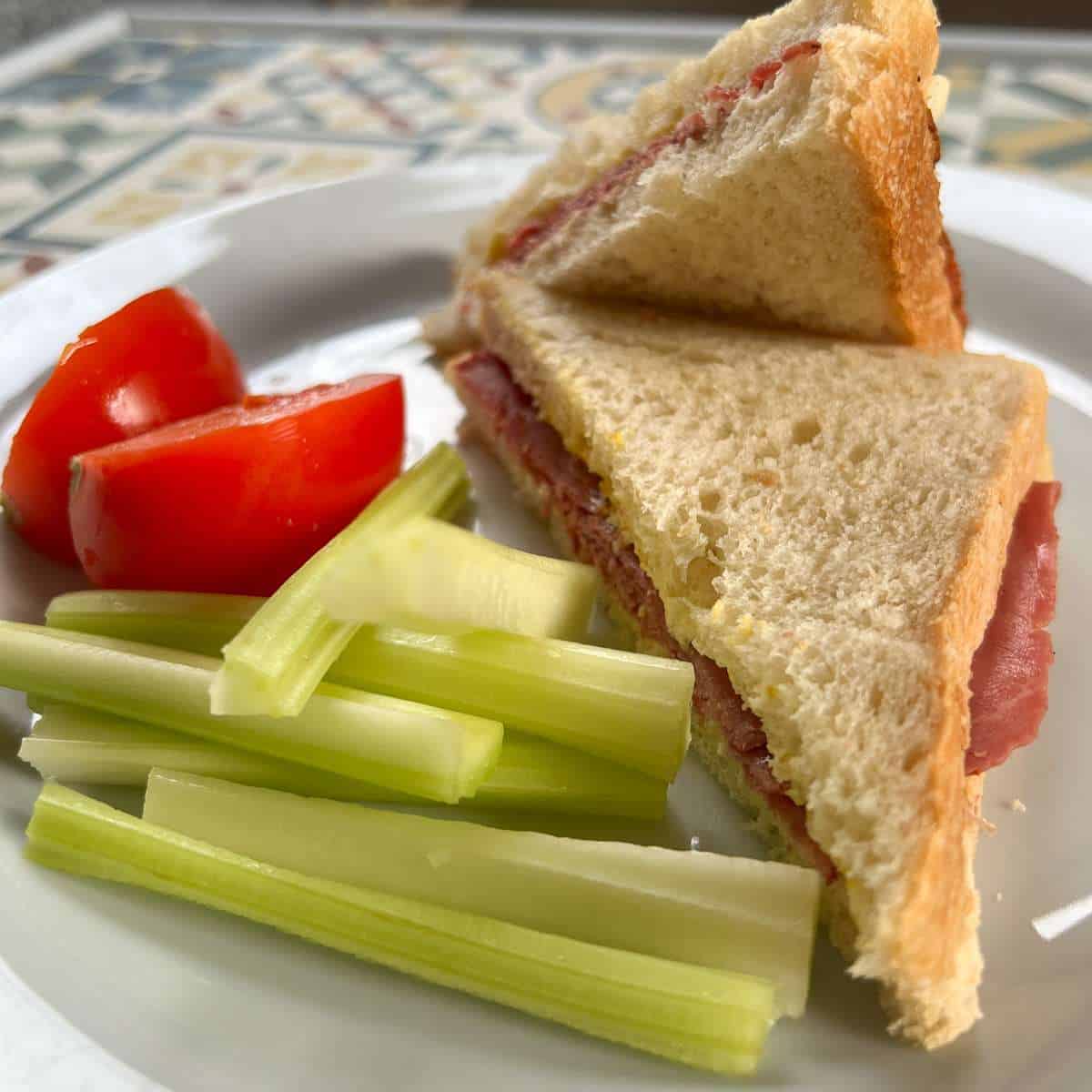 Image of Pastrami and mustard sandwich on a plate.