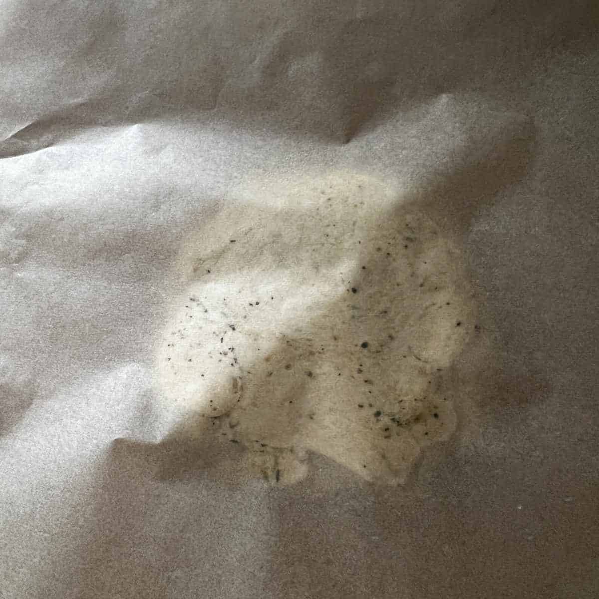 Dough between sheets ready for rolling.