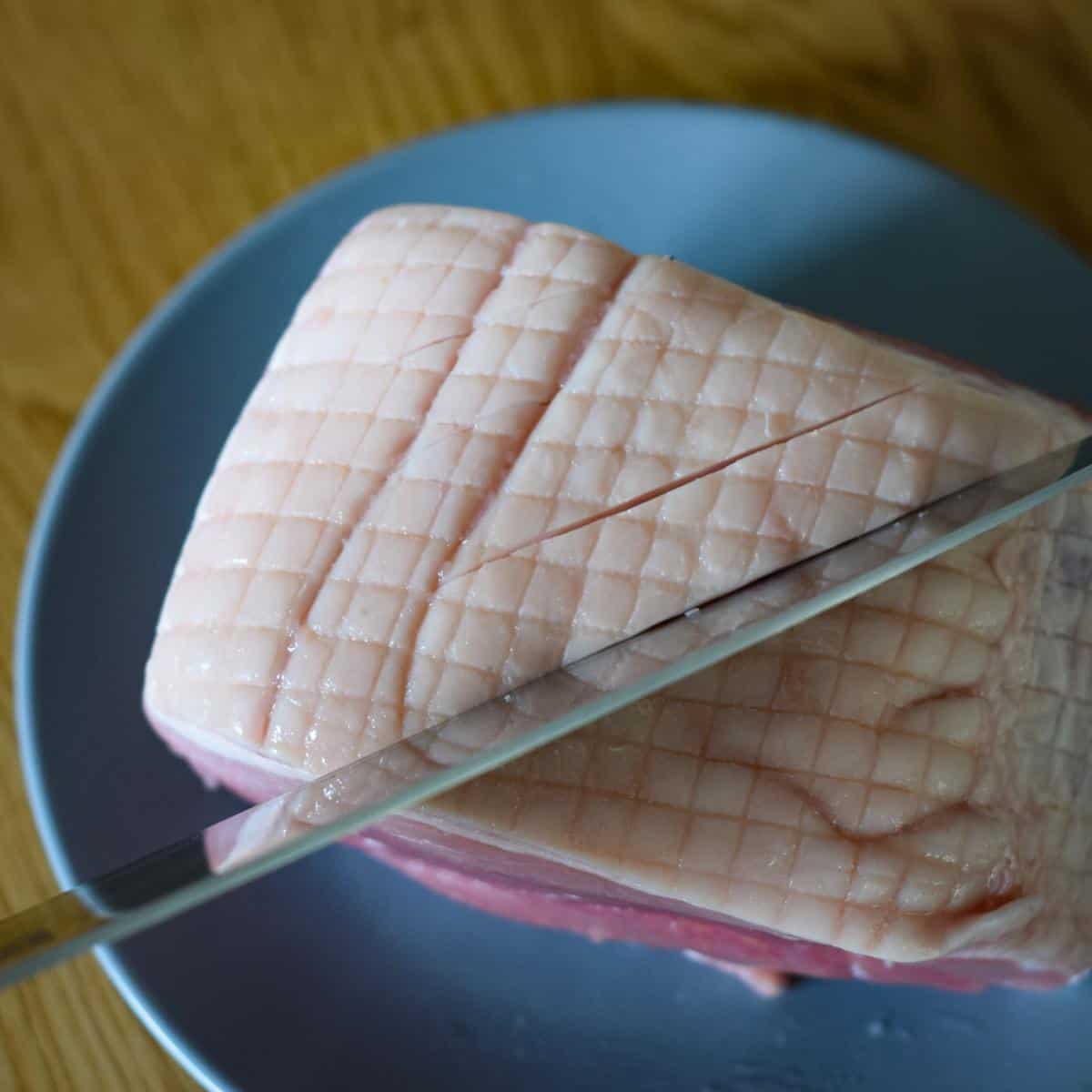 Slicing a gammon slits into the fat.