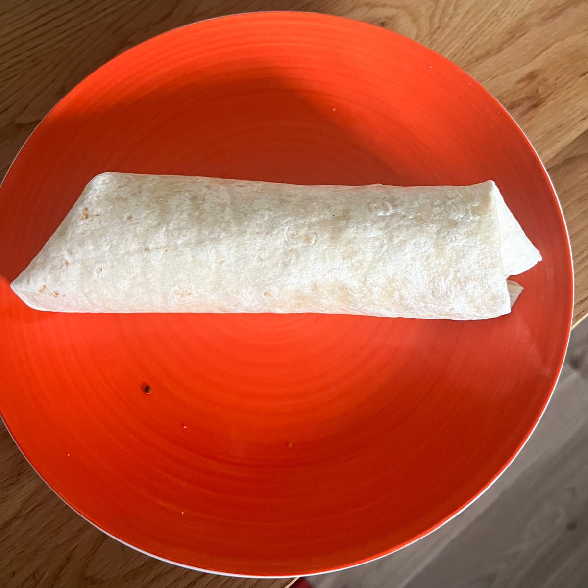 Fully rolled wrap on a plate.