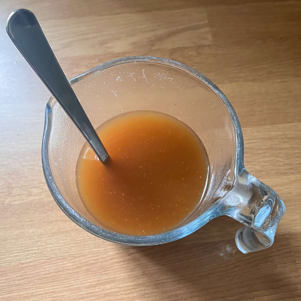 Beef stock mixed in water in a jar.