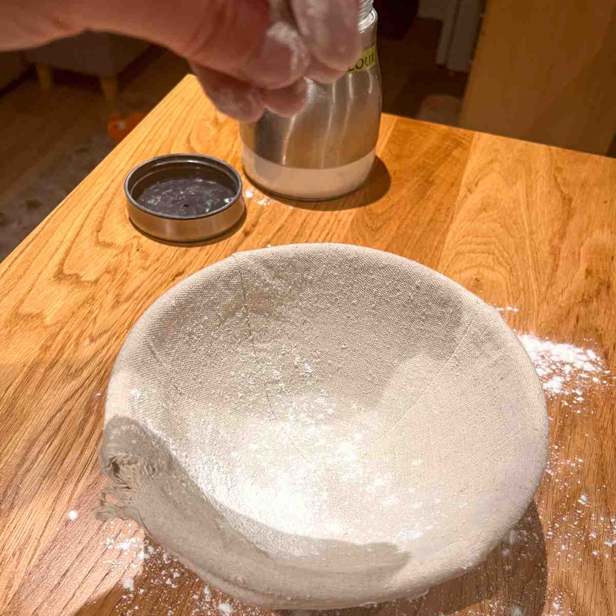 Adding rice flour to a banneton basket.