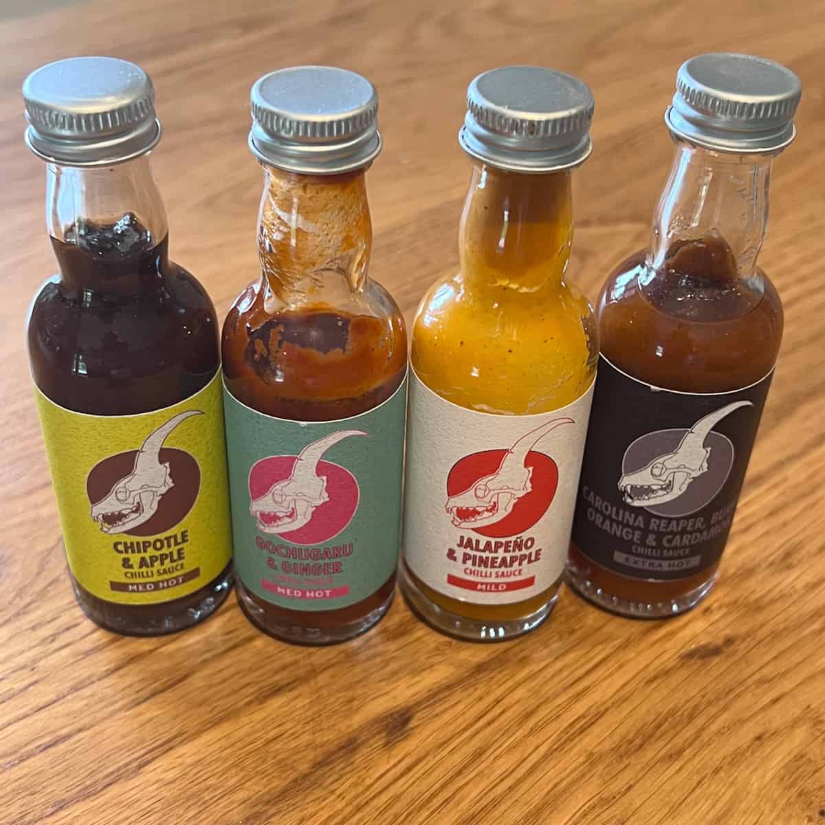 Various bottles of hot sauce on work top.