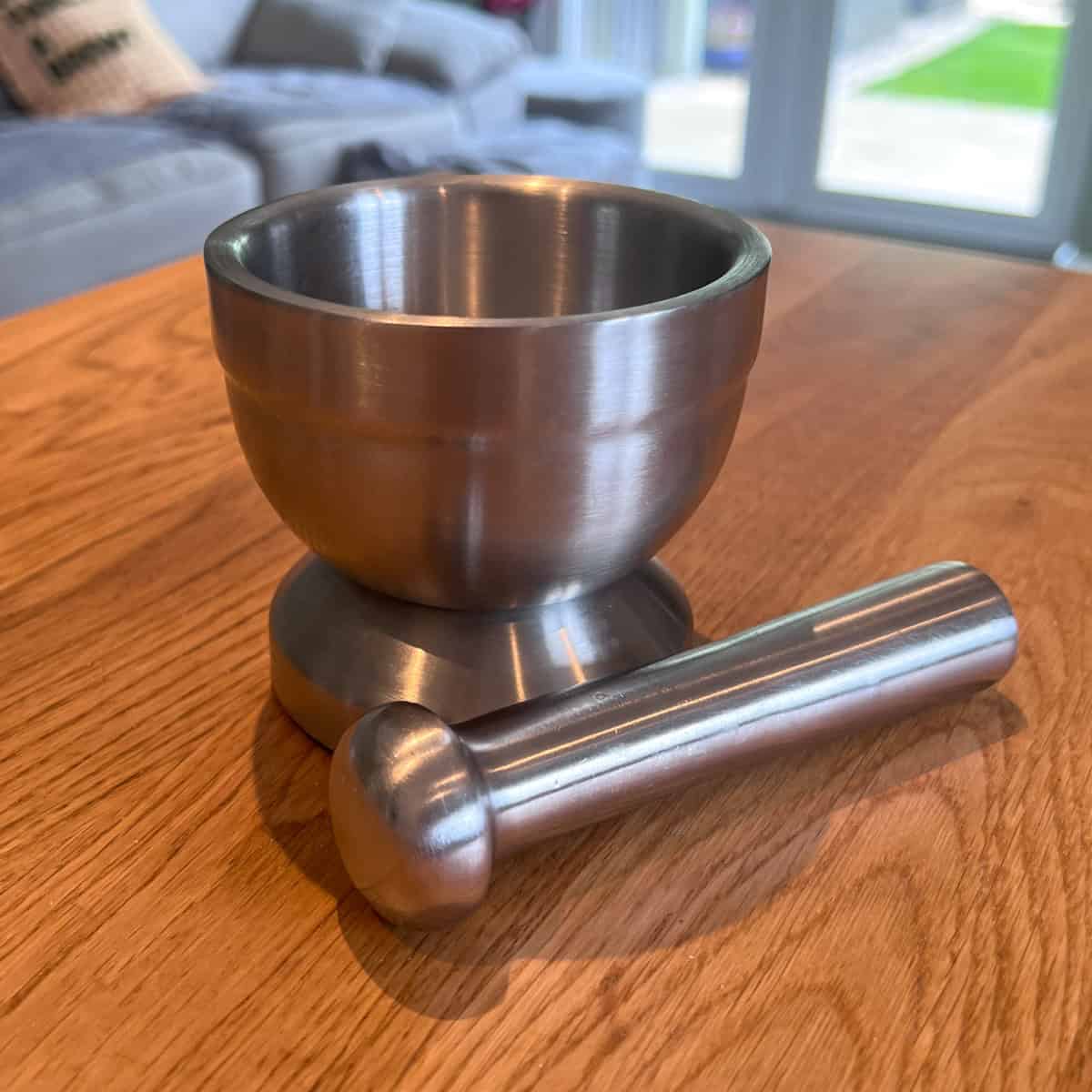 Metal pestle and mortar dish.