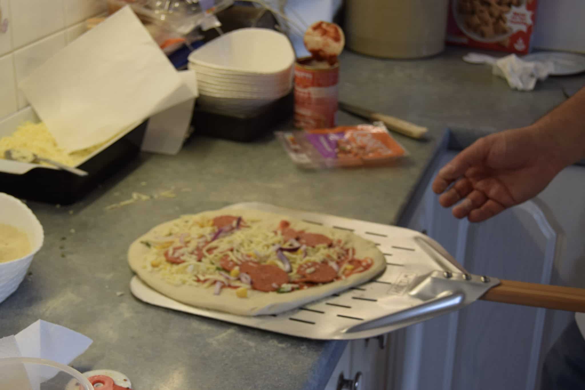 Making a pizza and sliding it on to a peel.